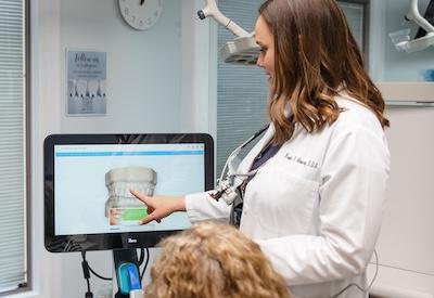 Dr Mooney showing a dental patient their teeth during an exam