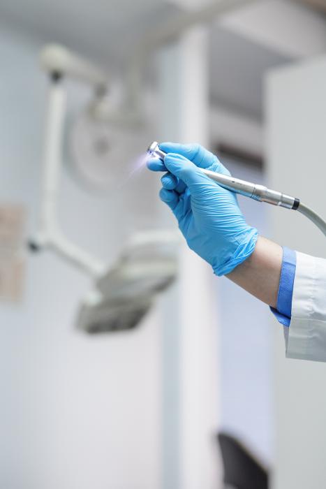 A dentist holding a dental tool in Arlington, VA
