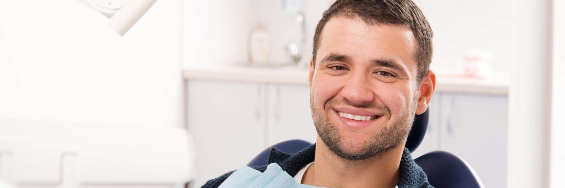 A smiling man sitting at the dentist