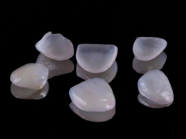 Four veneers placed on a dark background