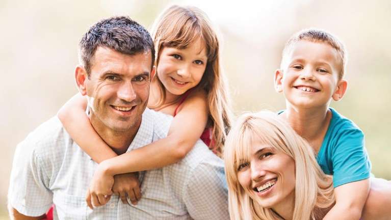 Two parents and two kids smiling