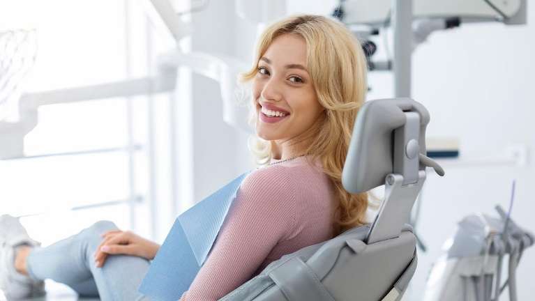 A smiling woman in the dental exam room