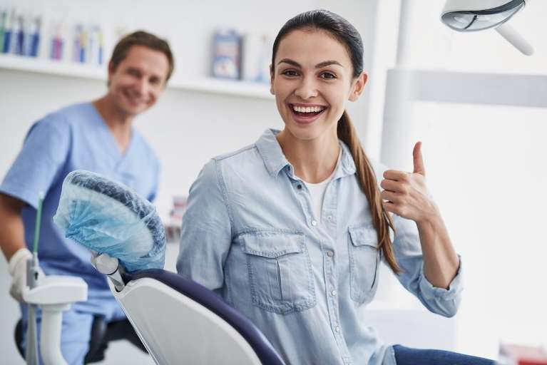 A smiling patient with her dentist
