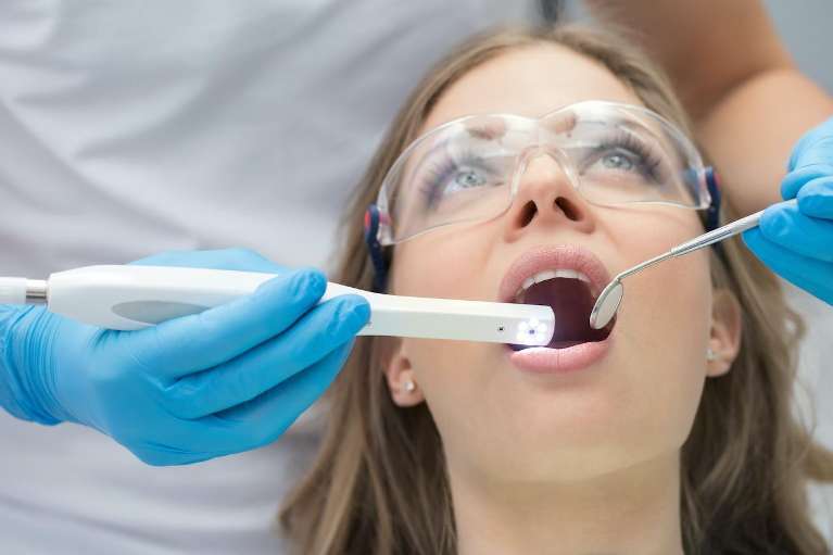 A woman getting her teeth cleaned during a dental exam in Arlington