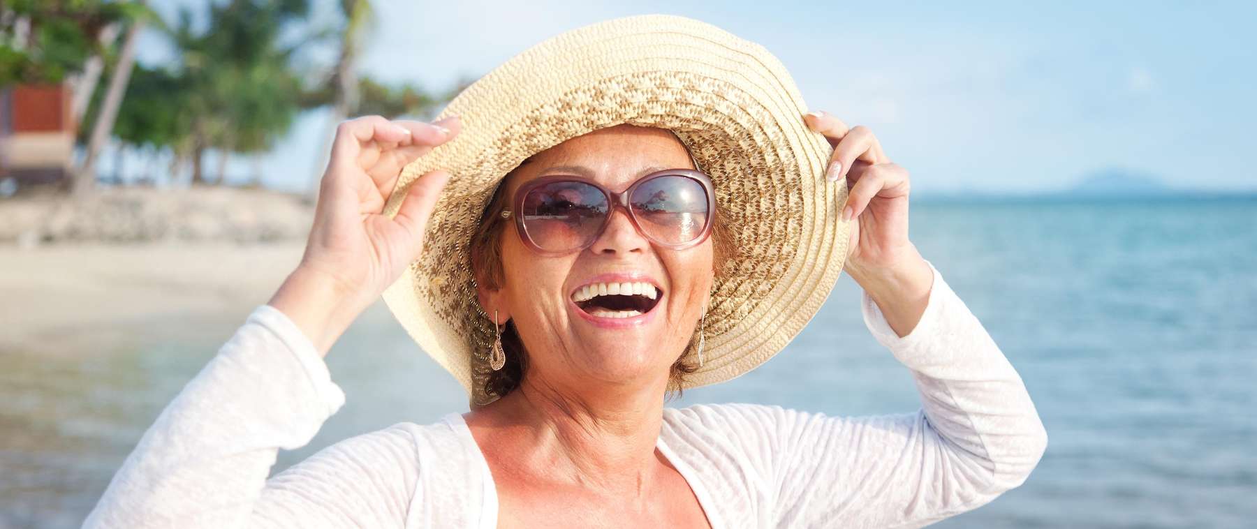A smiling older woman on the beach