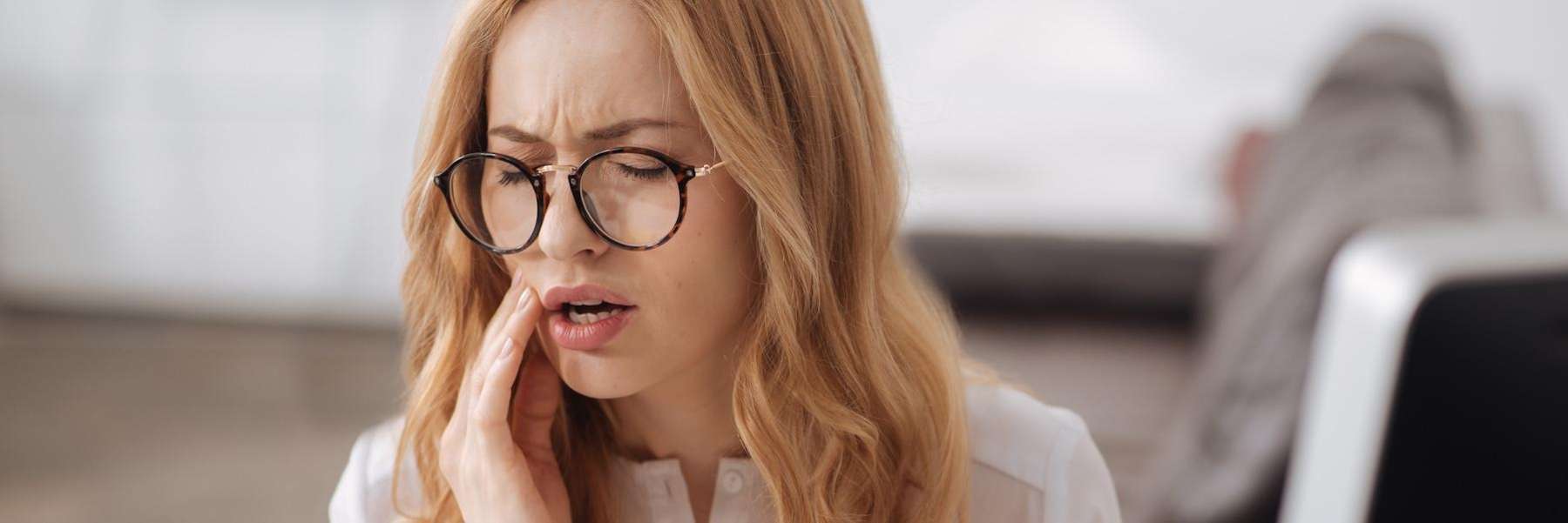 A woman with jaw pain from stress grinding