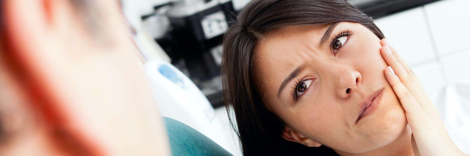 A woman with a chipped tooth talking to her dentist