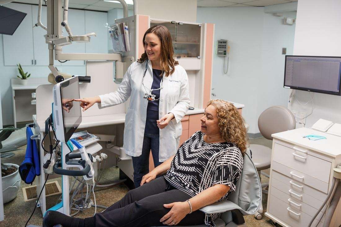 Dr. Brigid Mooney showing a patient their digital teeth scans in Arlington, VA