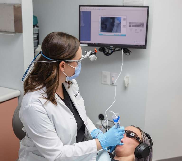 A dentist using an intraoral camera at Clarendon Family Dentistry